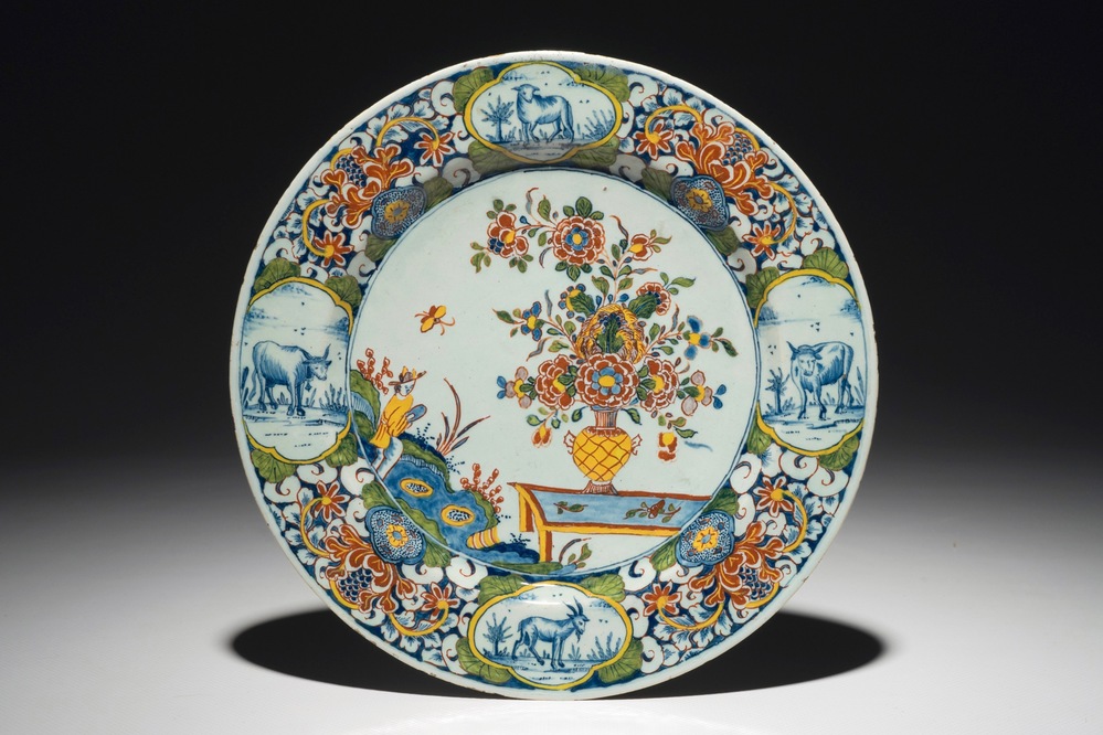 A fine Dutch Delft mixed technique plate with a central flowervase, 18th C.